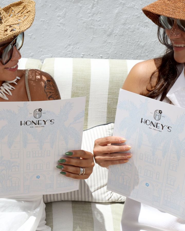 two guests reading menus on a lounge sofa