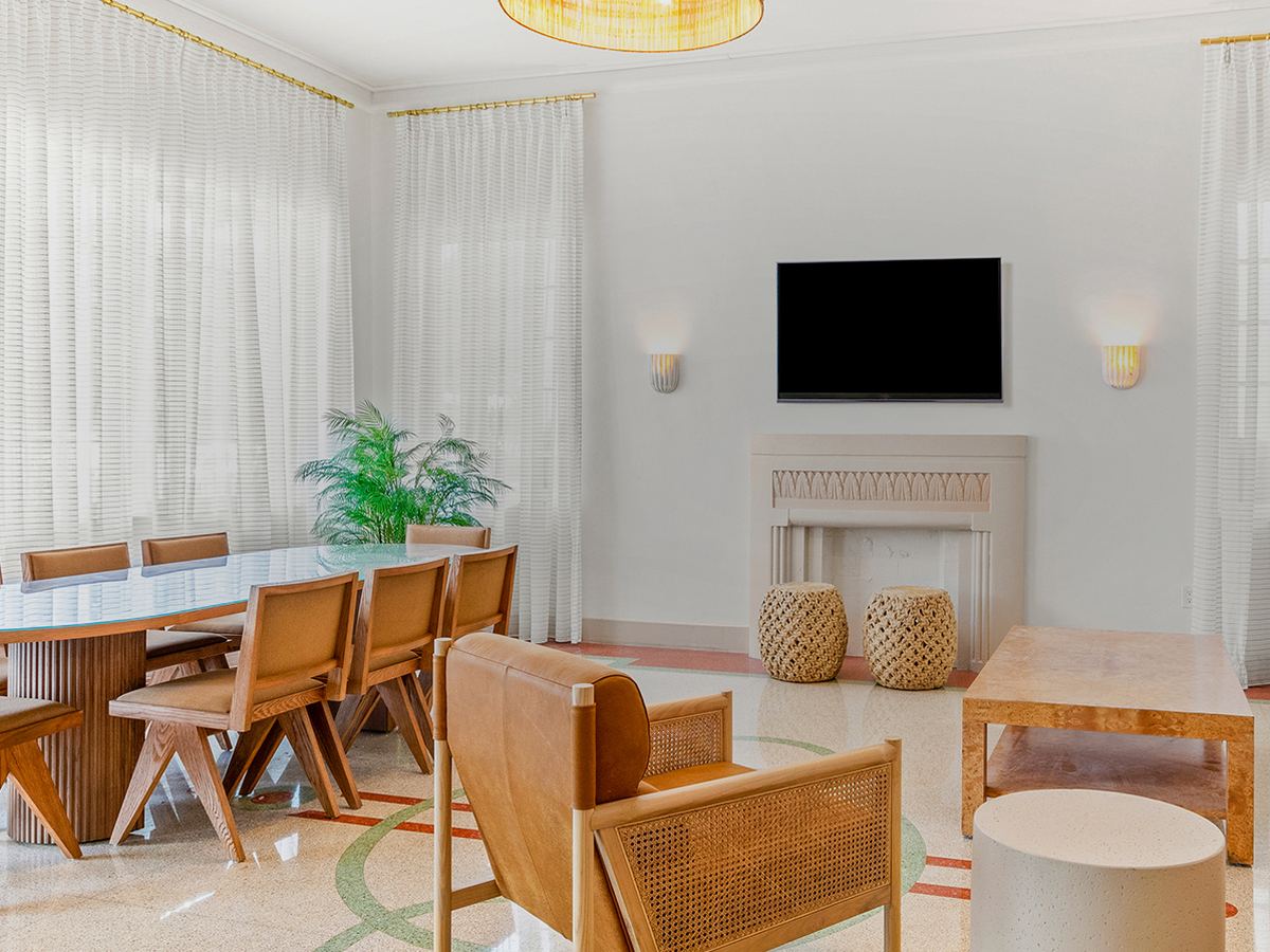 a bright lounge with armchairs and a long table