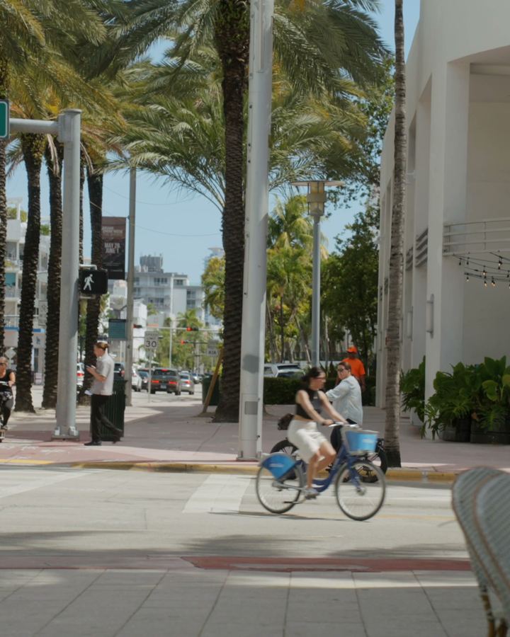 ciclistas y mesas de café en Collins Avenue