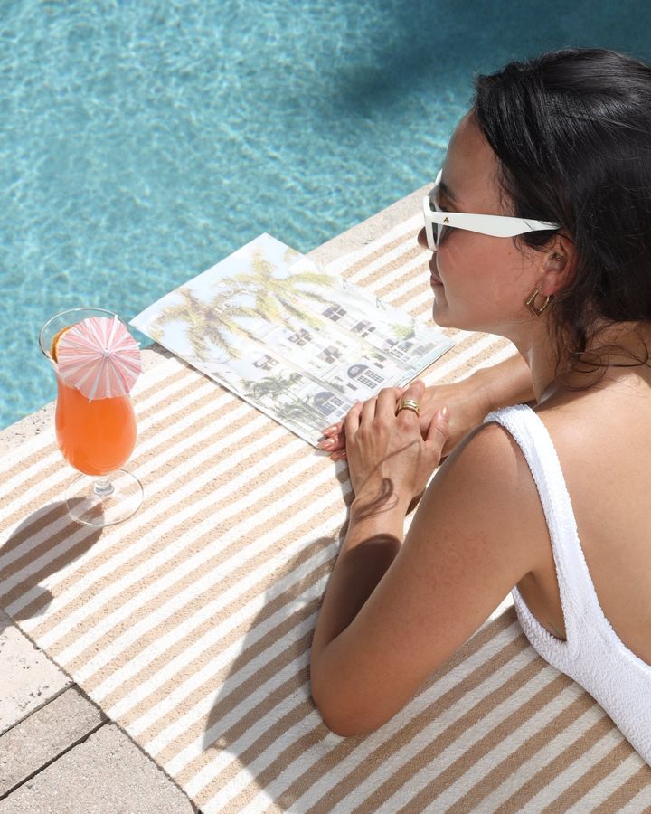 a cocktail and sunglasses by the pool