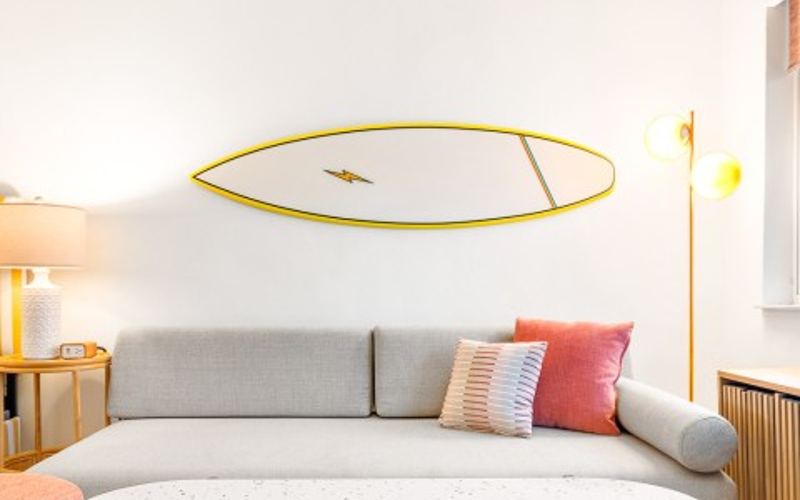 la sala de una suite con una tabla de surf en la pared
